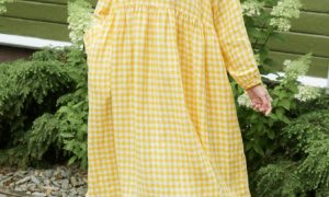 model posing with a yellow gingham linen dress in oversized fit and full length sleeves