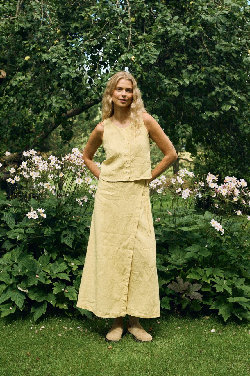 Sleeveless light yellow linen button-up top paired with a matching A-line wrap midi skirt
