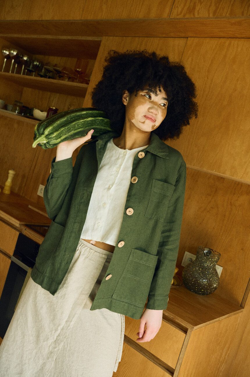 Layered look featuring an unbuttoned utility jacket over a cropped top and wrap skirt